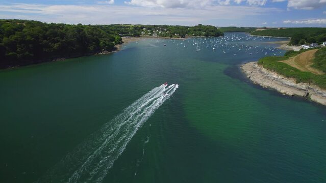 Aerial shot floowing speed boats as they make their way up the Helford River in Cornwall (part of sequence)