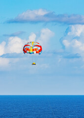 Fototapeta na wymiar Parasailing towed behind a boat in the Caribbean sea, tropical Ocean, Vacation Concept, Cancun, Mexico