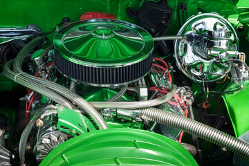 Muscle car engine in close up. Automobile accessories concept. Internal green color, shiny, and...