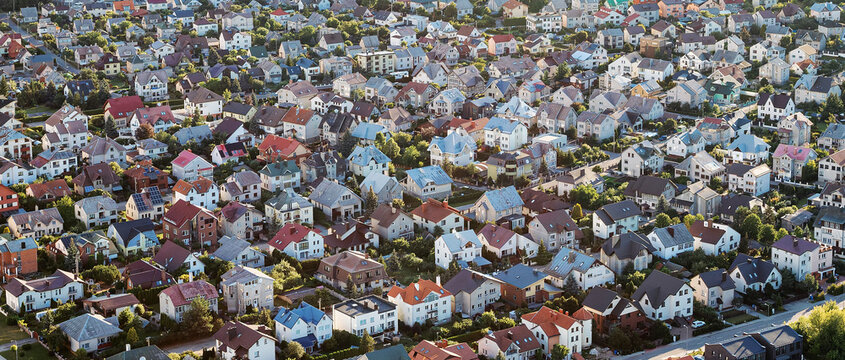 Settlement with many houses in a small town, photographed from above. Wide angle panoramic photo with real estate, suitable for web banner