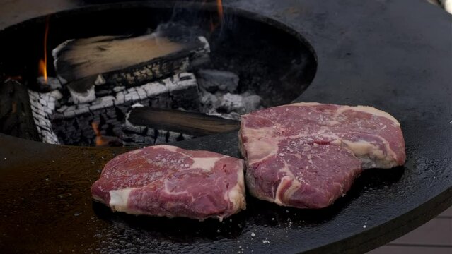 Closeup Shot Of Two Pieces Of Raw Steaks Being Cooked On A Grill