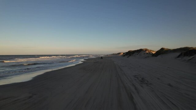 Aerial view of sea waves crashing into the sandy beach of Outer Banks island North Carolina