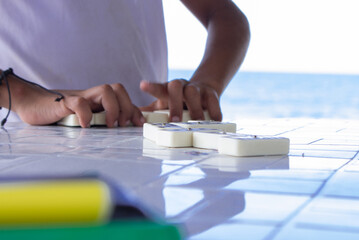 A kid playing dominos in a Colombian beach