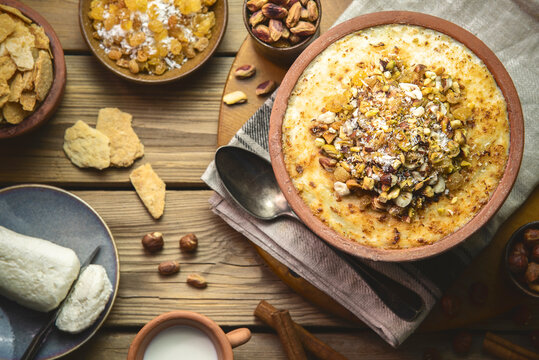 Arabic Cuisine; Traditional Egyptian dessert "Om Ali" or "Umm Ali" of soaked bread, milk and load of roasted nuts and raisins. Top view with close up.