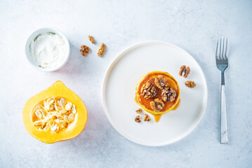 Pumpkin pancakes with walnuts and caramel sauce in a plate