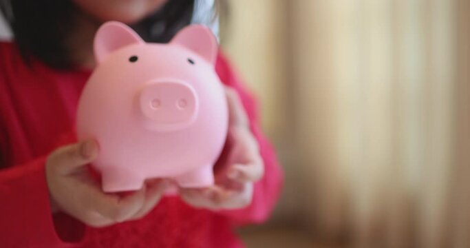 4K Video slow motion asian kid hug her piggy bank. Concept for financial and saving bank for child.