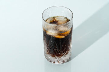 A glass of iced cola on a hot summer day