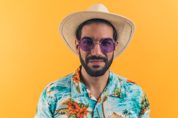 Hispanic man with beard wearing straw hat sunglasses and patterned short-sleeve shirt looking into camera. Tourist. Studio shot. High quality photo