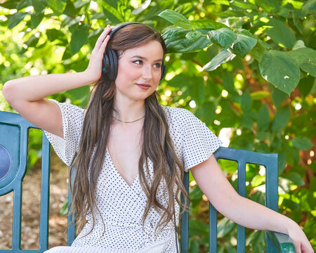 Woman Listening To A Podcast In The Park