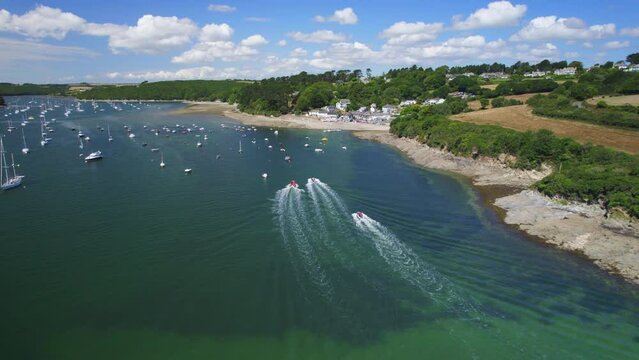 Aerial shot floowing speed boats as they make their way up the Helford River in Cornwall (part of sequence)