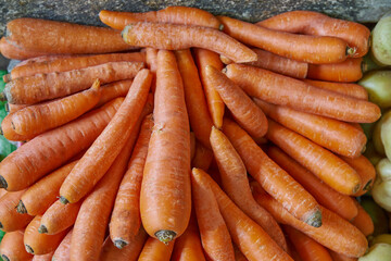 Stacked and sorted carrots placed on a shelf for sale at a market