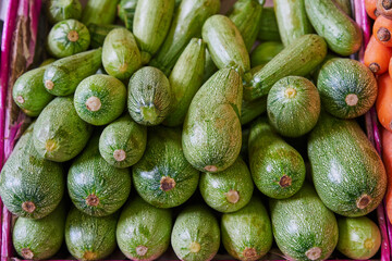 Stacked zucchini on a shelf for sale within a market