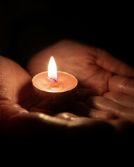Hands holding candle