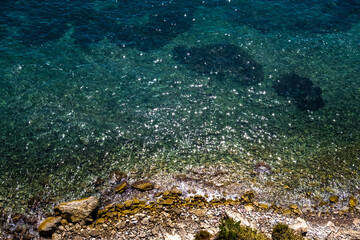 View of the transparent water of the sea on the coast from the rocky cliffs, natural background.
