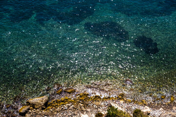 Fototapeta premium View of the transparent water of the sea on the coast from the rocky cliffs, natural background.