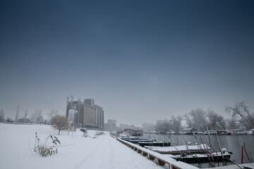 Selective blur on Panorama of Tamis river, on Pancevo Waterfront in center of city, during cold winter snow storm. silos are visible in background. Pancevo, Serbia, one of biggest cities of banat