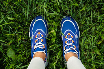 Woman's legs in blue sneakers outdoor, close up. Modern sport fashion concept.