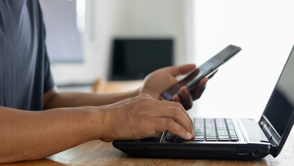 Cyber security and information security, Man using smartphone and working with laptop on table, Business concept smart phone technology conversation conference. Working from home concept.