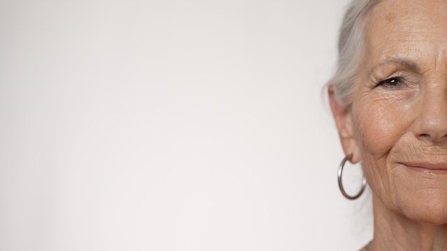 Half Portrait Of Smiling Pretty Senior Elderly Woman On Solid White Background.