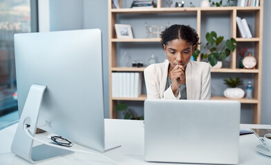 Young confident, focused and thinking businesswoman sitting alone in an office and browsing the internet on a computer. Ambitious creative professional planning and thinking of ideas at a desk