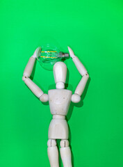 Mannequin Wood Figure carrying an incandescent light bulb. New idea concept. green screen