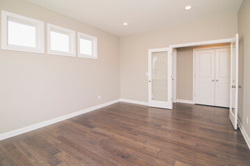 empty room with hardwood floors and a door. 
