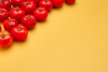 Top view of ripe red acerola cherries on an orange background