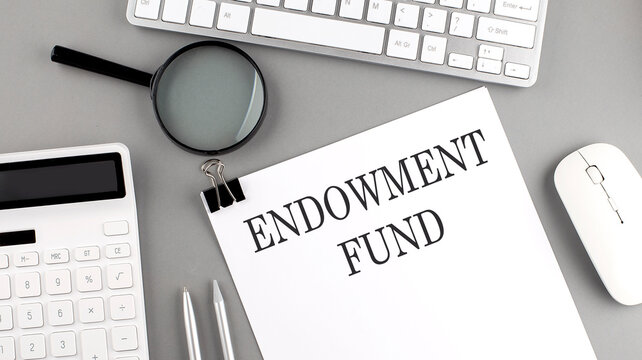 ENDOWMENT FUND written on paper with office tools and keyboard on the grey background