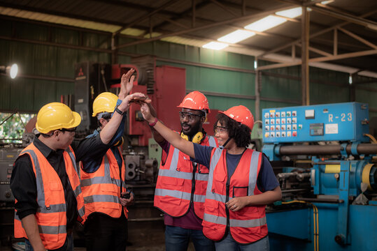 group of diversity teamwork engineers, technician, foreman and workers in safety uniform are happy morning talk and putting hands up to starting work in heavy industrial manufacturer factory.