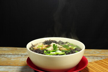 Traditional hot soup of fresh seaweed and minced pork serving in the bowl. Famous soft and light menu for easy digestion. 