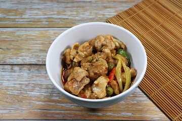 Fried spicy chicken with herbal vegetable serving in the bowl. Famous traditional starter menu in Chinese restaurant. 
