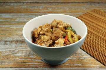 Fried spicy chicken with herbal vegetable serving in the bowl. Famous traditional starter menu in Chinese restaurant. 