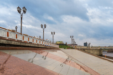 Architectural geometry with reflection on the embankment of the river in Tyumen (Siberia, Russia) on rainy summer day.