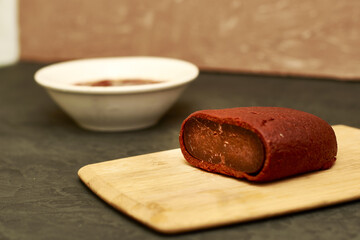 basturma on a wooden cutting board next to a plate with spices