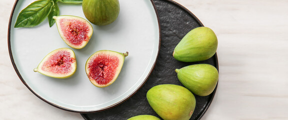 Plates with fresh green figs on light background, top view