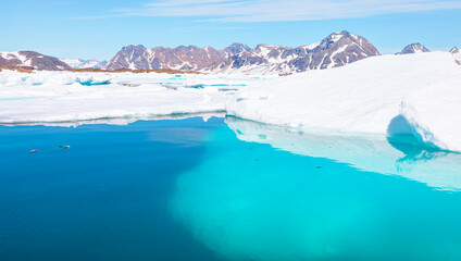 Melting icebergs by the coast of Greenland, on a beautiful summer day - Melting of a iceberg and pouring water into the sea - Greenland