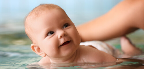 Adorable little baby with mother in swimming pool, closeup