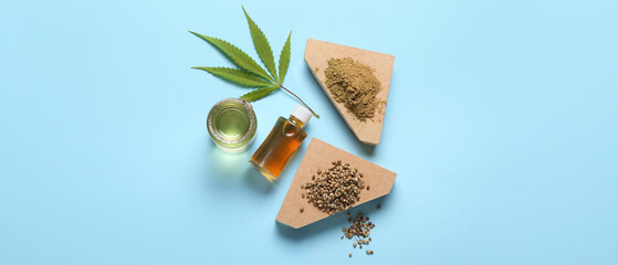Composition with hemp oil, seeds and powder on blue background, top view