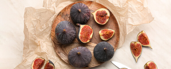 Plate with fresh figs on light background, top view