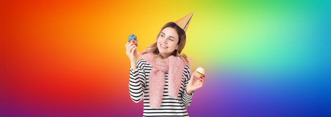 Beautiful young woman with birthday cupcakes on rainbow background