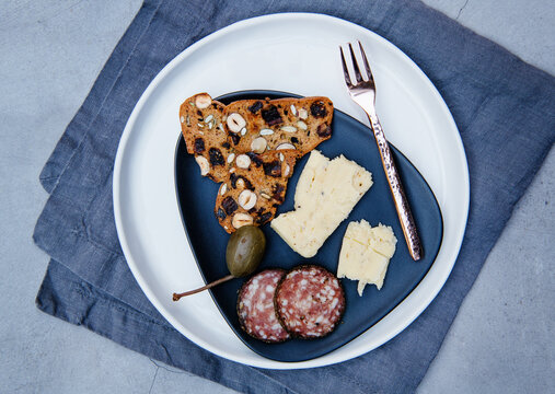 Appetizer of gourmet cheese, Salami, crackers and caperberries
