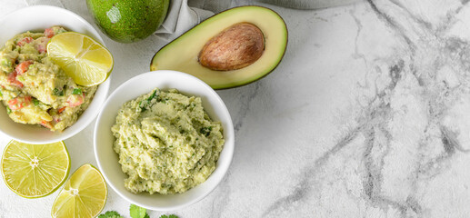 Bowls with tasty guacamole on light background with space for text
