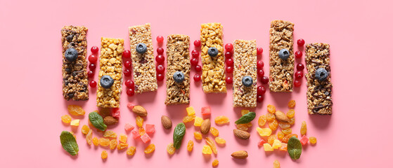 Healthy cereal bars, berries and nuts on pink background, top view