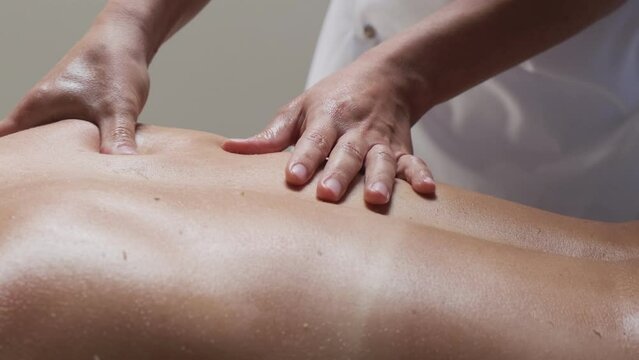 Woman massage therapist massages the girl's back. Massage room
