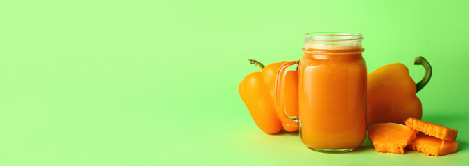 Mason jar of fresh vegetable juice on green background with space for text