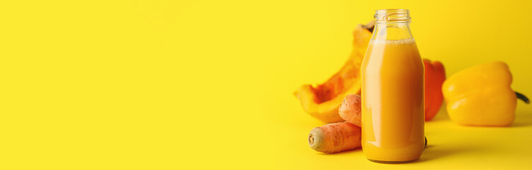 Bottle of fresh vegetable juice on yellow background with space for text