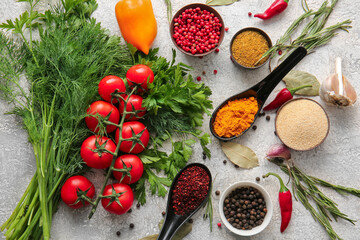 Different spices, vegetables and herbs on light background