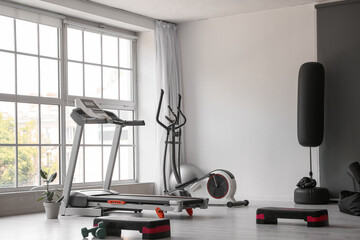 Interior of modern gym with treadmill and sport equipment