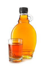 Bottle and glass of maple syrup on white background