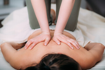 Fototapeta na wymiar Back massage in a massage salon, woman having a relaxing back massage.